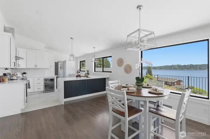 Spacious kitchen and dining area featuring expansive, picturesque views of Budd Inlet.