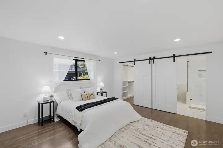 Primary bedroom featuring a spacious walk-in closet and a private en-suite bathroom.