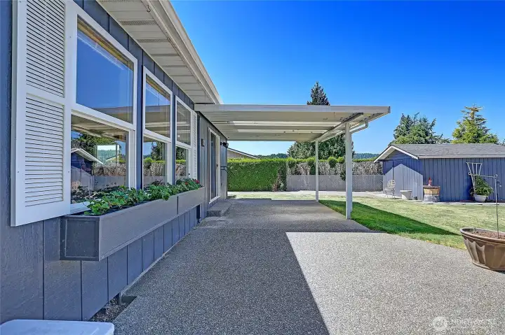 Large back patio that is partially covered but extends across the back of the house.