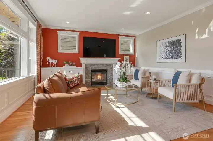 Warm and inviting, the family room is anchored by a beautiful fireplace, custom built-ins, elegant wainscotting and crown moldings.