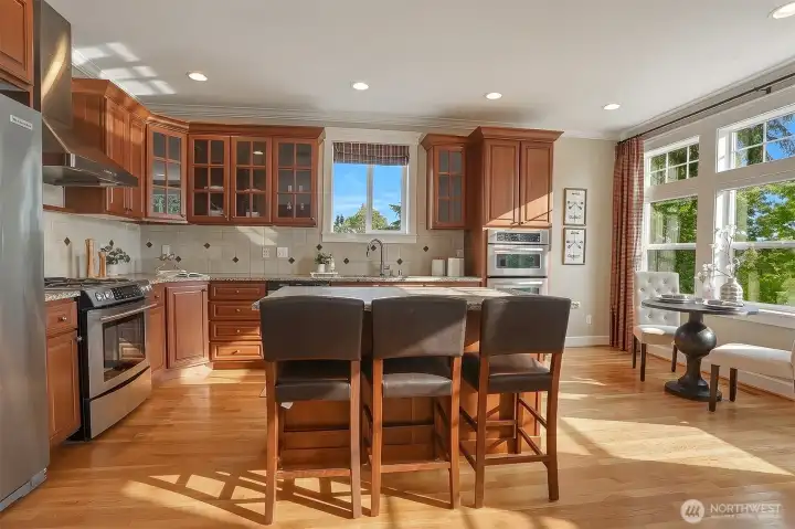 Designed for both everyday living and entertaining featuring a generous island with seating, and a sunny breakfast nook.