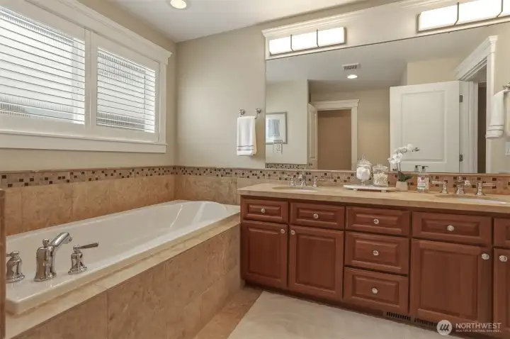 The ensuite offers double sinks complemented by beautiful travertine tile and a polished, sophisticated design.