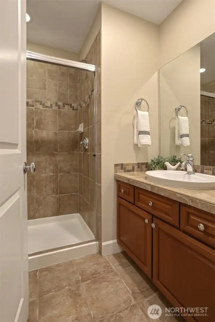 Three-quarter bathroom conveniently serves the lower-level bedroom and recreation room.