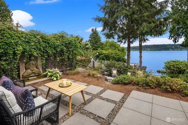 Zen inspired patio with serene lake and garden views.