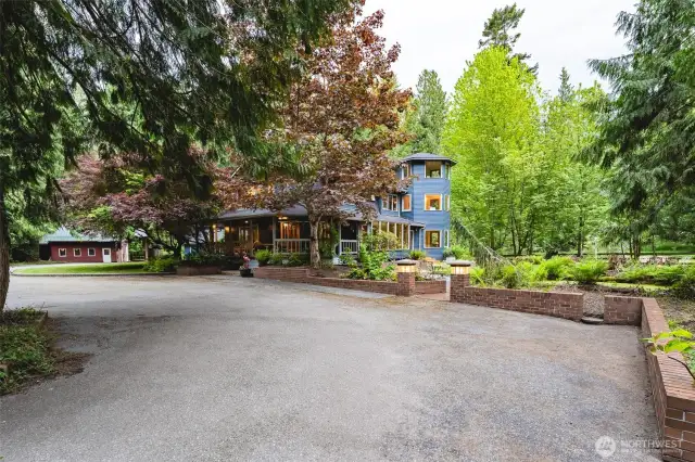 The first glimpse of the home is captivating. Asphalt drive, brick masonry around the perimeter of the home and courtyard.