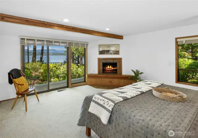 Primary Bedroom with wood fireplace, private deck, and views of the Mountains and Hood Canal