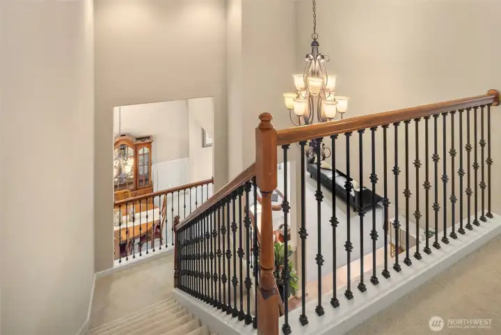 The lovely staircase with stylish metal railings and a beautiful chandelier