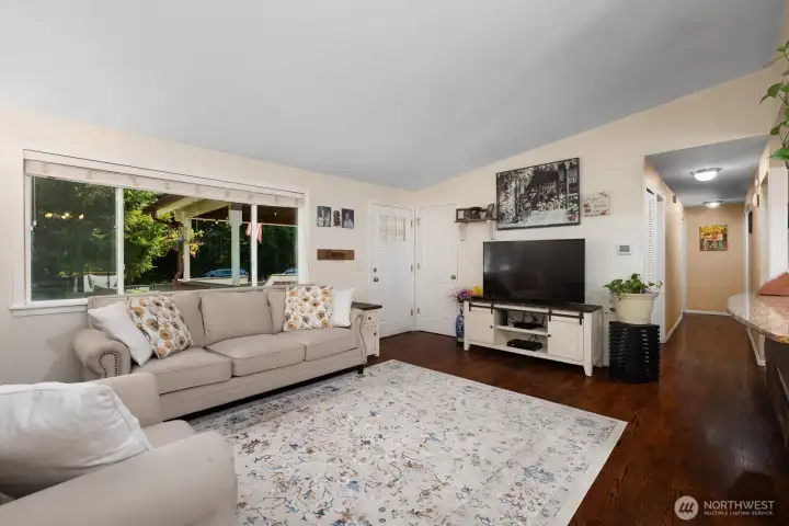 Living Room view looking towards the front door. Vaulted ceilings open up this space even more.