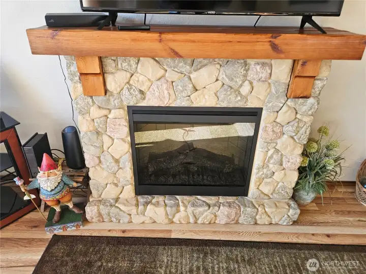 The lovely rock surfaced fireplace is electric for ease of use, adding to the beauty and comfort of the living room.