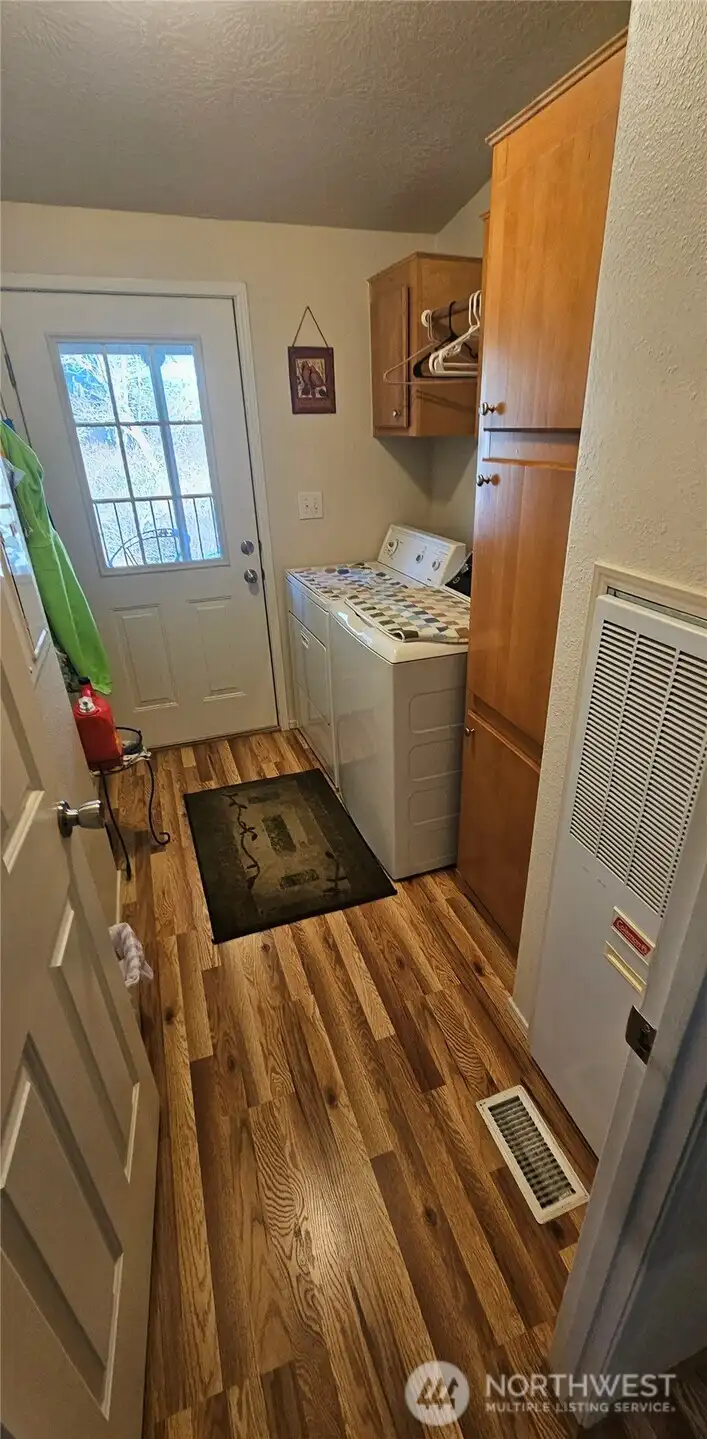 Utility room with plenty of cabinets leads through the door to the deck at the back of the house.