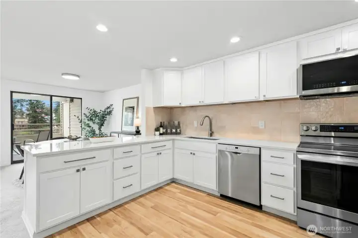 New, modern kitchen with LVP floors, Stainless Steel appliances, quartz counters, and lots of cabinet space.