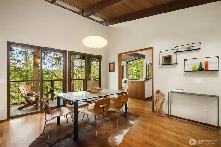 Sliding doors connect the dining area with one of two main floor decks.  Those double entry doors are out of frame on our right, along with a cute powder room.  We've got a first glimpse of the kitchen straight ahead, but for now let's turn left and check out the living room...