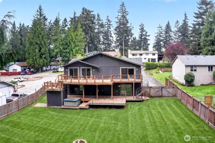 Large level fenced backyard offers room to roam and entertain with 2 decks and covered space for year round outdoor fun
