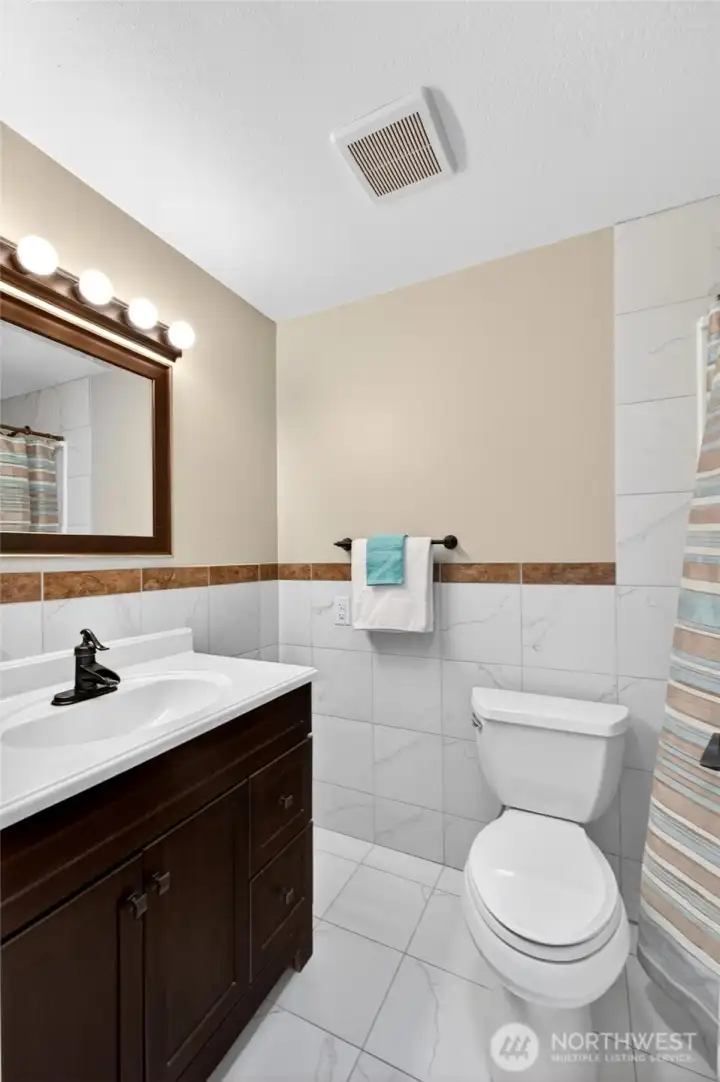 Refreshed full bath in upstairs hallway is one of 3 full baths in this home