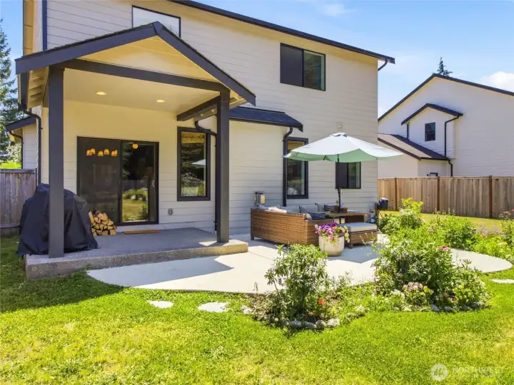 Covered patio extended with large concrete pad and more flower beds with drip irrigation.