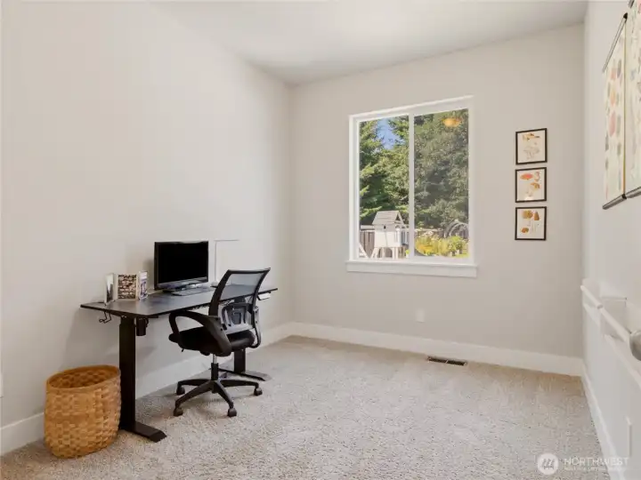 First floor bedroom with walk-in closet. Currently used as office, with view of backyard.