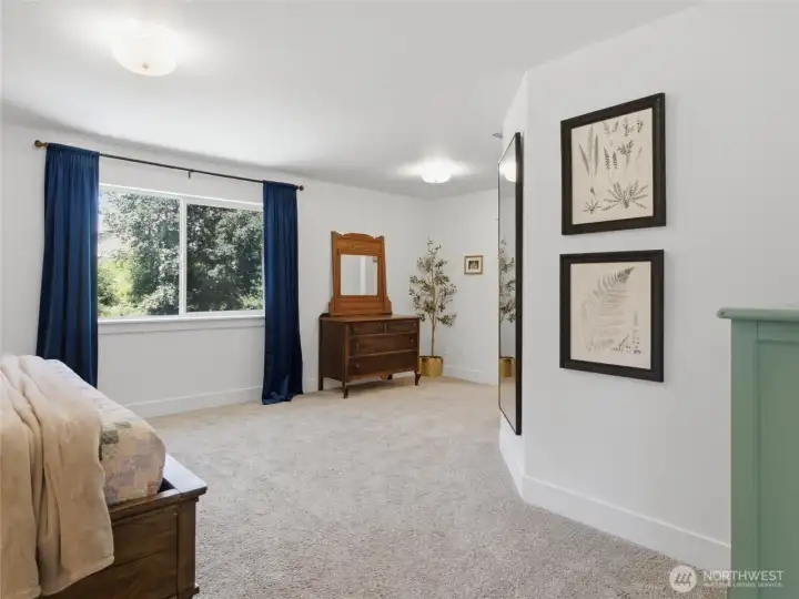 Spacious primary bedroom with view of backyard.