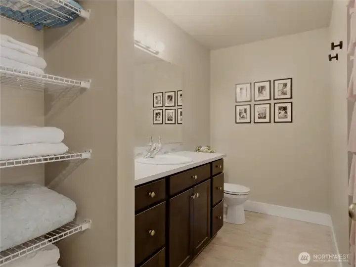 Spacious full upstairs bathroom with linen shelving.