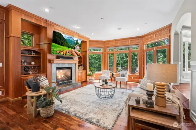 Heading back inside, just off the kitchen gather and cozy up in this lovely family room with a gas fireplace, gorgeous built-ins, and double doors out to the expansive deck!