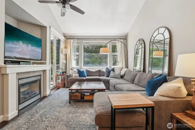 Gas fireplace, ceiling fan and large windows to forest view.
