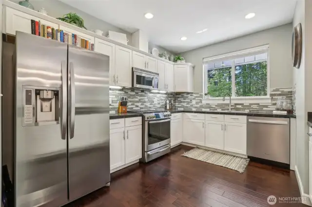 Kitchen has ample cabinetry, work space and view to forest