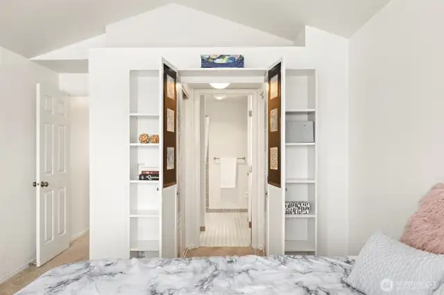 Clever bookshelves hide the opening to the walk-in closet leading to shared bathroom.