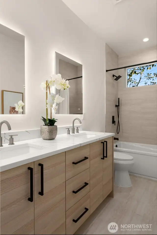 Full bath with dual sinks and a combo shower/tub.