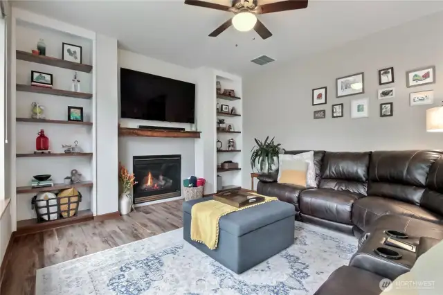 As you walk down the hall from entry, you will find this beautiful family room open to the kitchen in the back of the home. I love the coz=y has fireplace and built-in shelving!