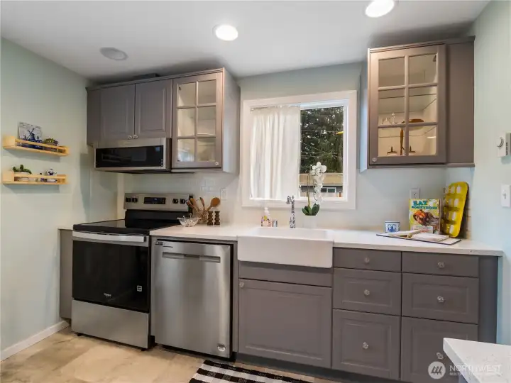 A brand-new stove and shiny stainless-steel appliances along with he gray painted cabinets give this kitchen a classy look that goes so well with the style of the home.