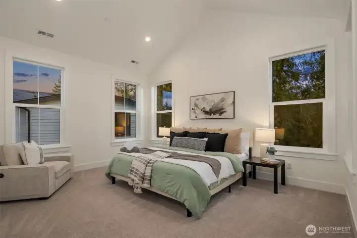 The primary bedroom feels expansive yet draws you into comfort and style. The vaulted ceilings and abundant windows bounce natural light all over the room.