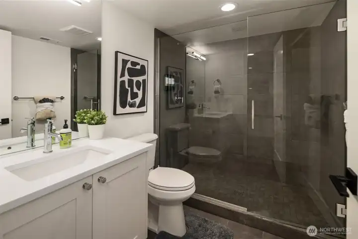 A well-dressed three-quarter bath serves the lower level with an impressive oversized walk-in shower, seamless glass door and handsome custom tile.