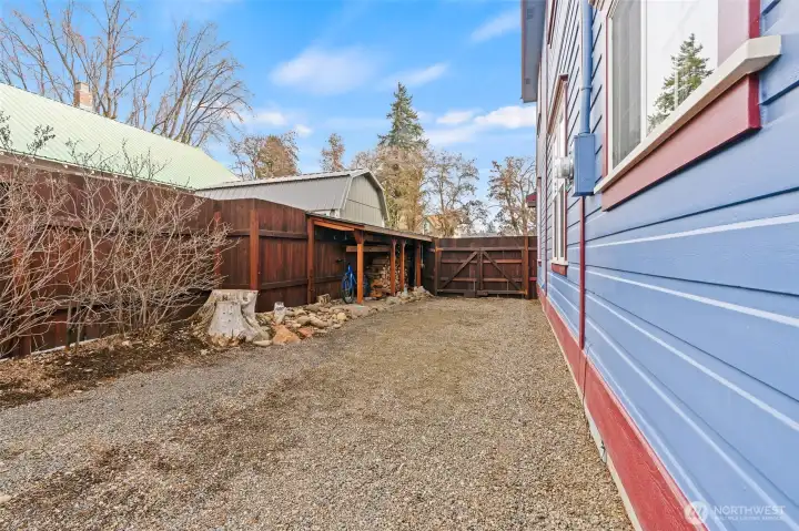 North side of the house offers a bike shed and firewood storage.