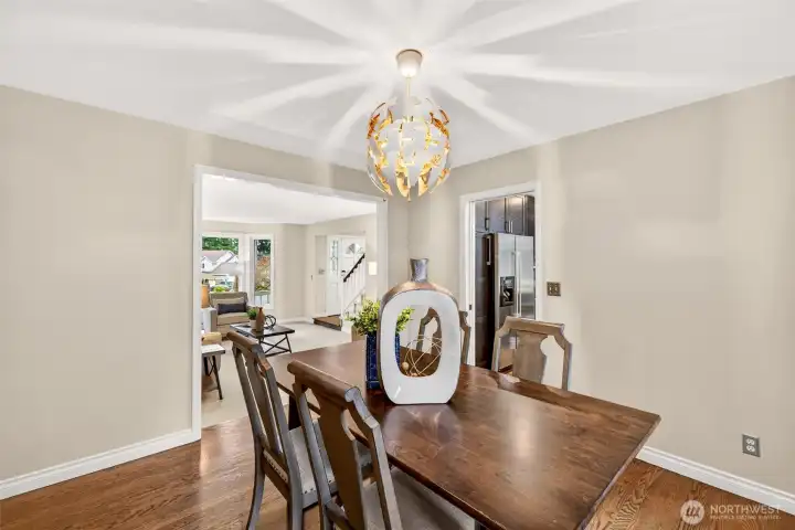 The dining room offers a true hosting space with hardwood floors and ample natural light. Thoughtful flow connects the dining space to both the living and kitchen for maximum function and ease.