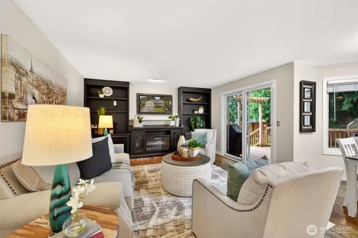 This inviting family room offers a relaxed setting with direct access to the outdoor living spaces through sliding glass doors. Built-ins and the electric fireplace add warmth and everyday practicality.