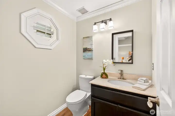 The main floor powder bath is a smart and stylish touch for guests, featuring a vanity with ample counter space. An accent window adds natural light and character to this convenient half bath.