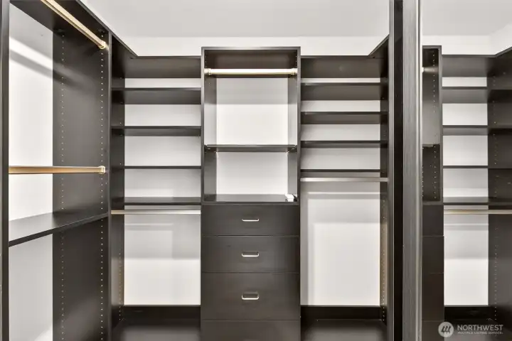The walk in closet is thoughtfully customized with built in shelving, hanging space, and drawer storage for an organized, boutique feel. Everything has a place, from seasonal items to daily essentials.