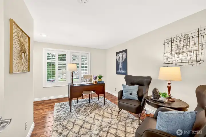 Another bedroom features hardwood floors and crisp, updated finishes for a clean, timeless feel. Plantation shutters add privacy and light control, creating a comfortable space for work, guests, or everyday living.