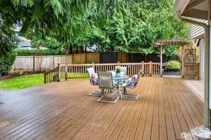 Step outside to an expansive, low maintenance deck that feels like an outdoor retreat. There is plenty of space for dining, lounging, and entertaining, with a natural evergreen backdrop that adds privacy.
