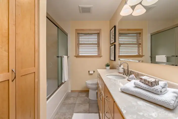 The main bath has been updated with new cabinetry, tile floors and new tub/shower surround.