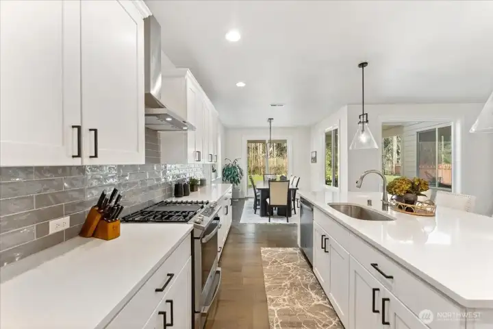 An impressive array of cabinetry with black cabinet pulls, offering elegant storage solutions throughout the kitchen.