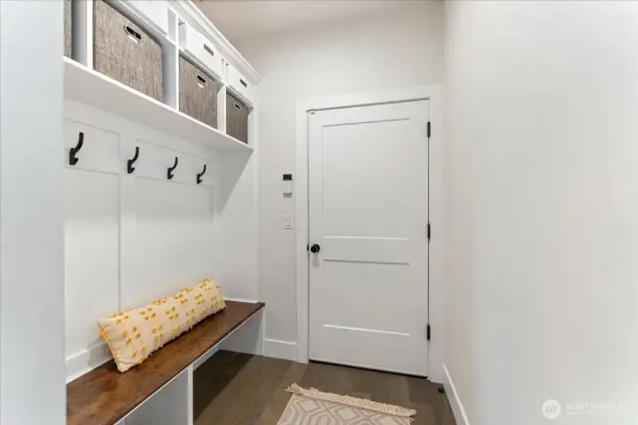 Functional and stylish mudroom with integrated bench, cubbies, coat hooks, and extra storage drawers for effortless organization.