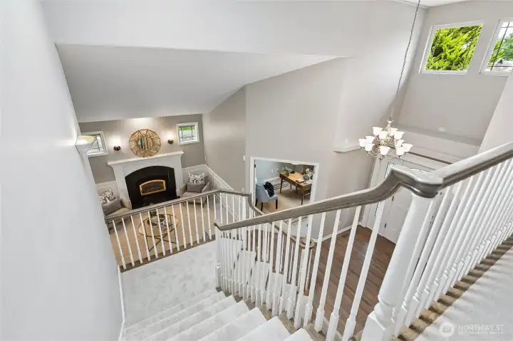 Ascending the grand staircase, you can look back over the elegant entry below, adding to the homes sense of openness and scale.
