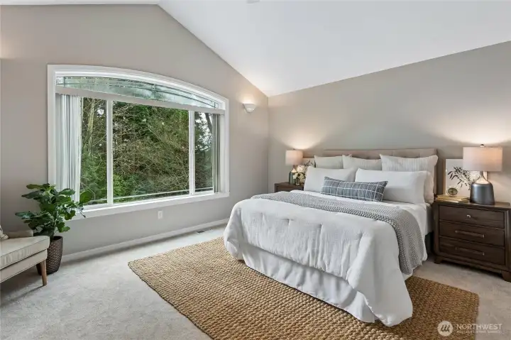 Accessed through double doors is the spacious primary bedroom featuring a vaulted ceiling with ceiling fan with light and oversize window that fills the room with natural light.