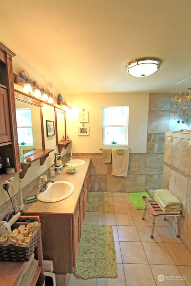 Indulge in luxury in this beautifully appointed primary bath, featuring heated tile floors for ultimate comfort.  The bathroom boasts serene ambiance and is the perfect retreat for relaxation and self-care.