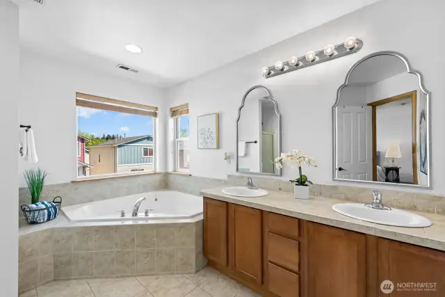 The primary bath features double vanity sink, separate shower, and large corner tub!