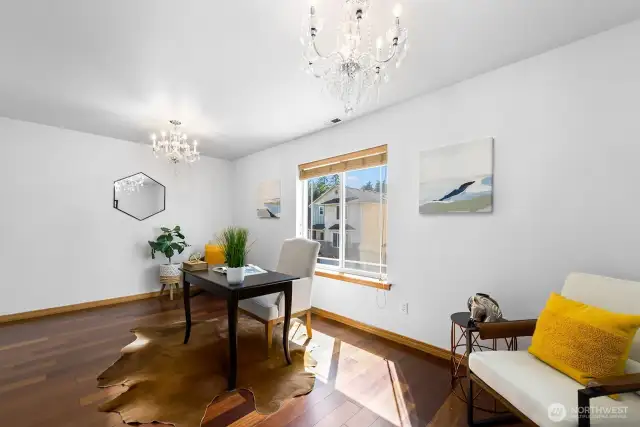 The main level office features hardwood floors and chandelier lights.