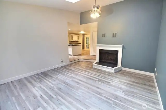Family room with wood burning fireplace, skylight and ceiling fan