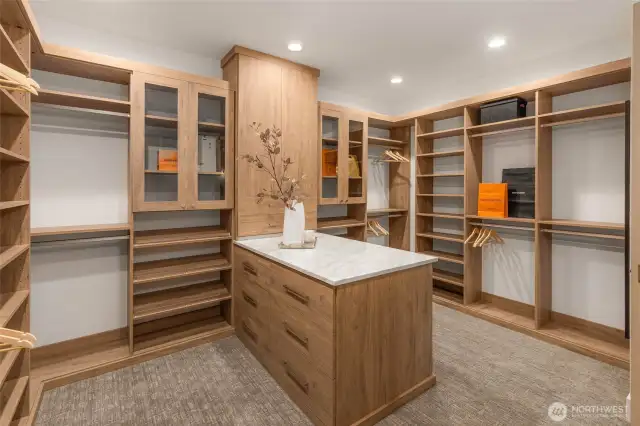 Large Primary Walk in Closet with Custom Designed Solid Shelving and Peninsula with Designer Slab