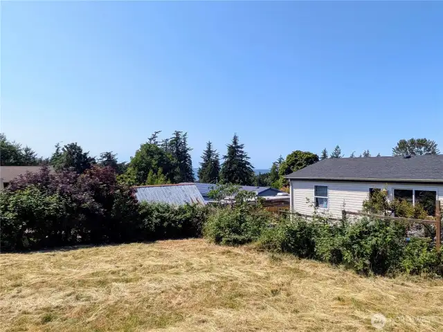 Large side yard with glimpse of the water.