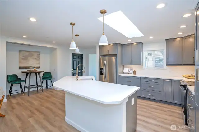 Huge island with Quartz Counters and plenty of seating - pretty pendant lights ensure a very bright eating area.